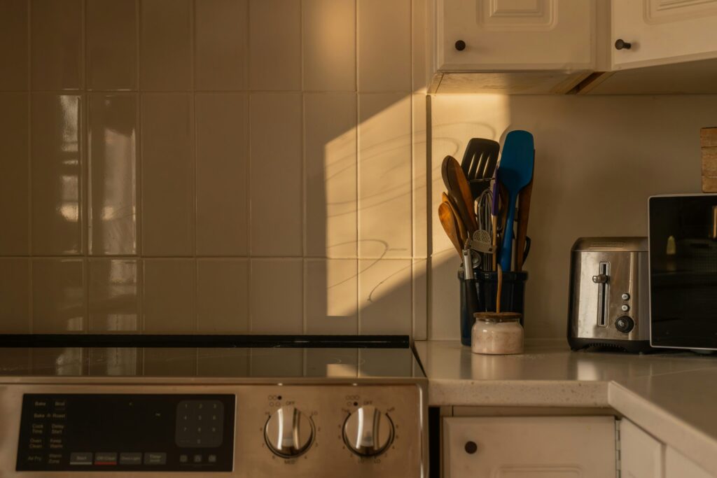 Sunlit kitchen with cooking utensils and countertop appliances